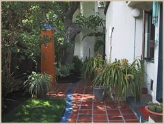 A side patio, with an outdoor shower, uses Gladding McBean terracotta piazza tiles.