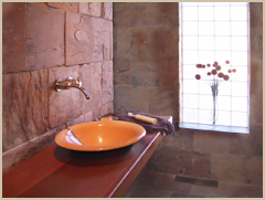 The master bath outfitted in natural materials of stone and wood.
