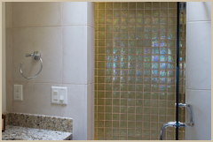 The powder room/ guest shower combines two types of stone with opalescent glass tile.