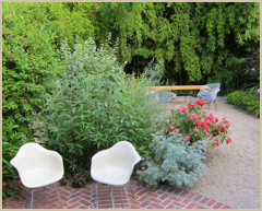 Lush plantings contrast the simplistic design of classic Eames shell chairs.