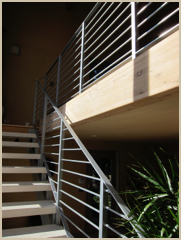 The open stairway, with its custom designed railings, leads to the mezzanine master bedroom.